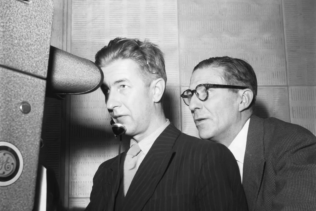 Two men at a microphone beside a camera during Finland's first television broadcast in 1950