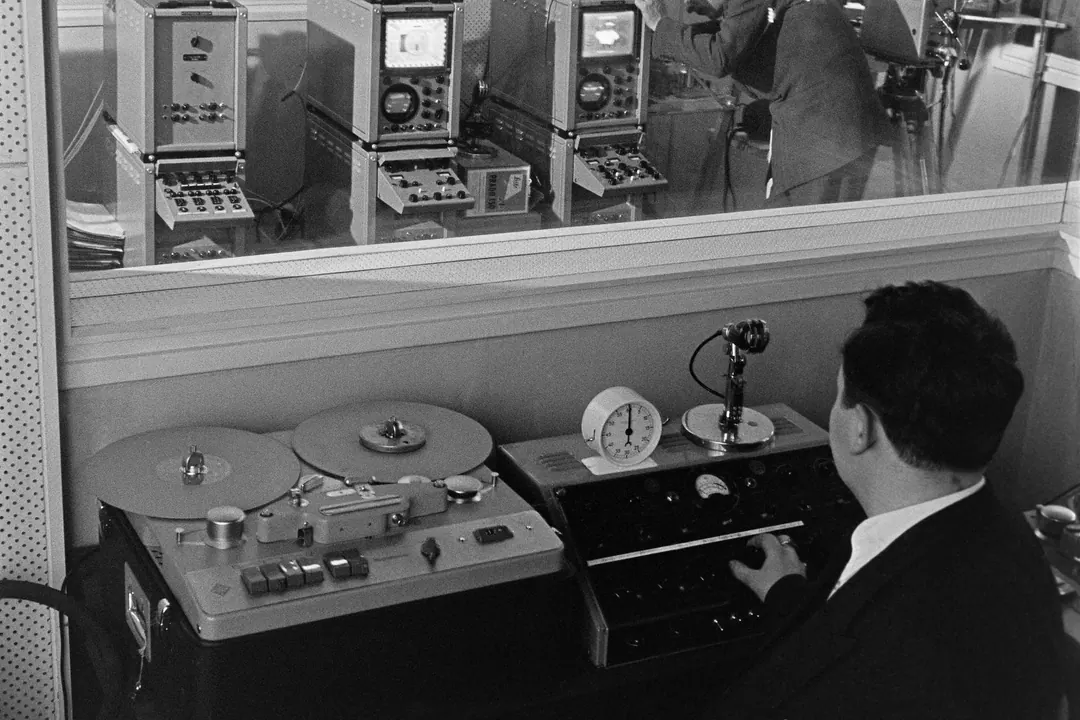 A control room looking through glass onto the studio during Finnish television test broadcasts in 1957