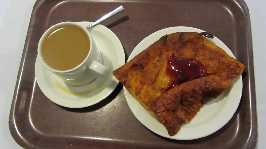 A table set with a cup of coffee and a Finnish pancake at Cafe Amurin Helmi in Tampere