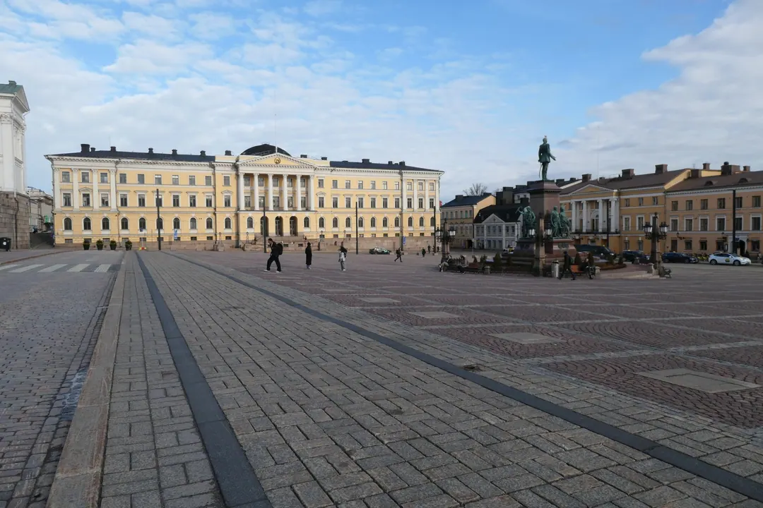 People crossing Senate Square in Helsinki on a spring afternoon