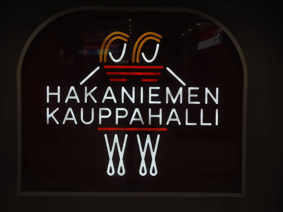 An illuminated sign at Hakaniemi metro station reading Hakaniemen kauppahalli