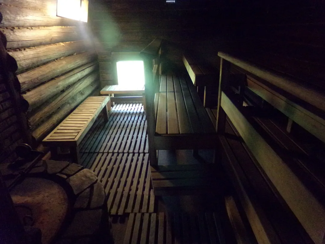 The wood-lined interior of the sauna at Tamminiemi, benches and a small window
