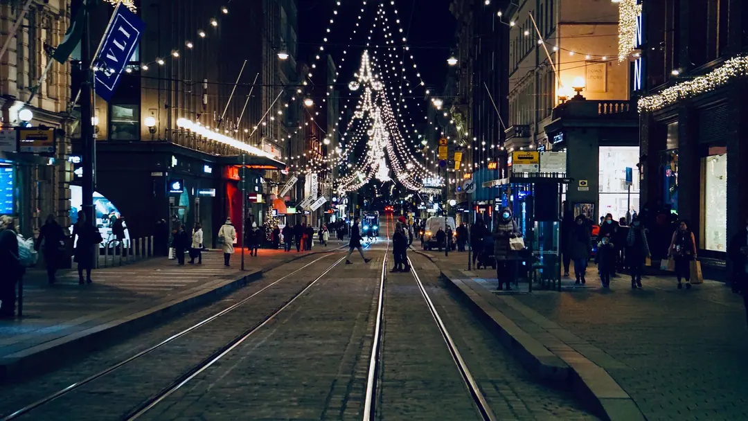 Helsinki city centre at night in December, trams and lit shopfronts