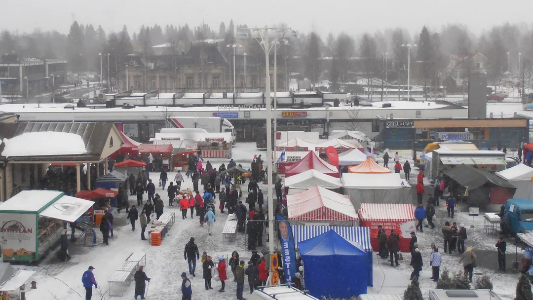 The winter market square in Iisalmi seen from above, stalls and crowds in snow
