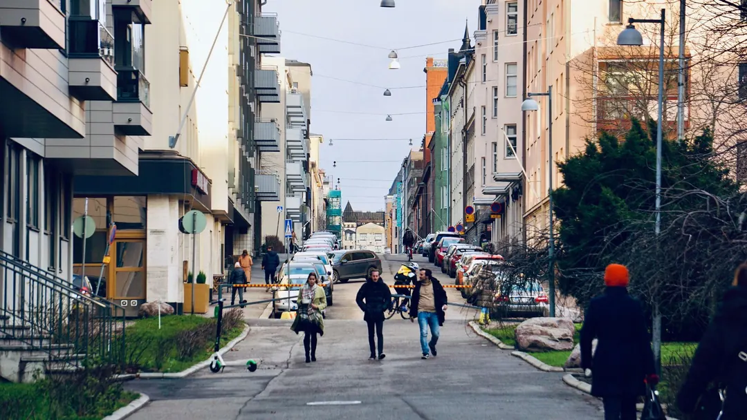 Pedestrians crossing a busy street in central Helsinki