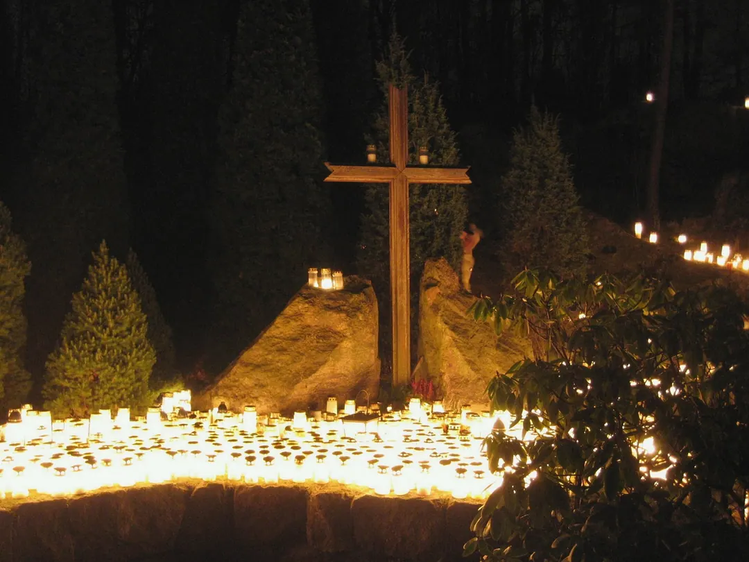 Hundreds of grave candles burning beneath a cross at Malmi cemetery on Christmas Eve
