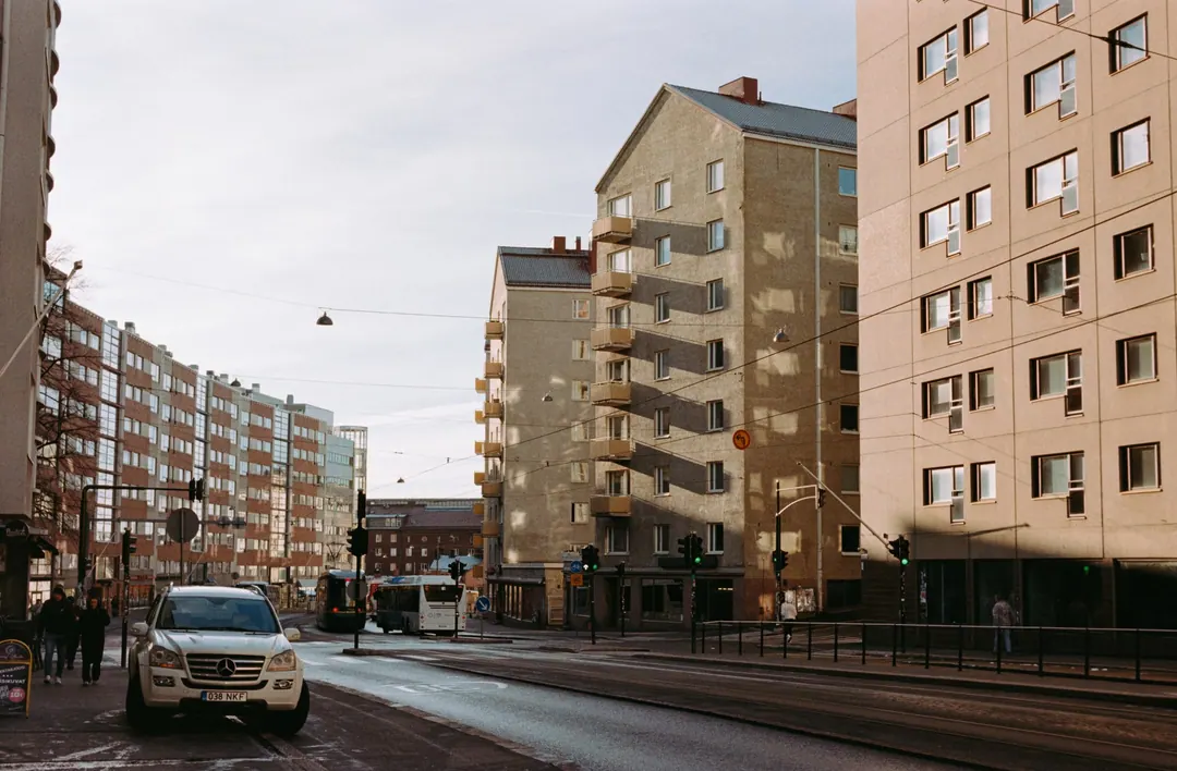 Hämeentie in Helsinki in low November sun, a car waiting at the lights and tram tracks curving away