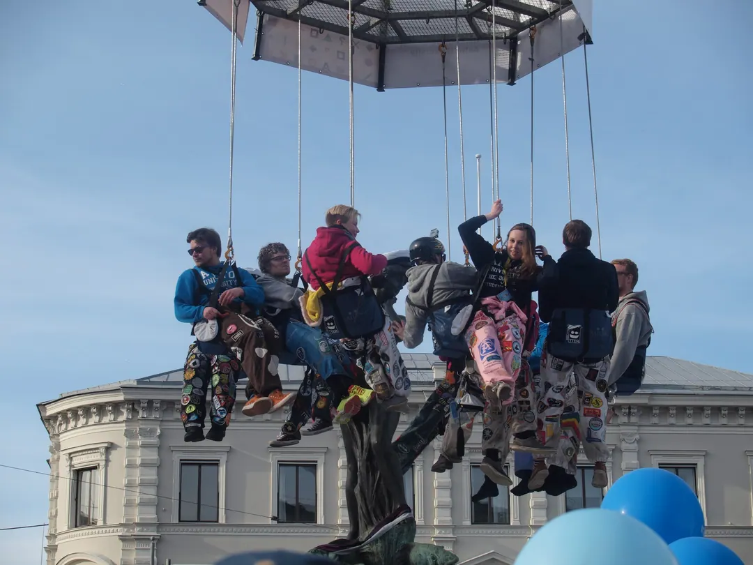 The Havis Amanda statue in Helsinki being given a white student cap above a dense crowd