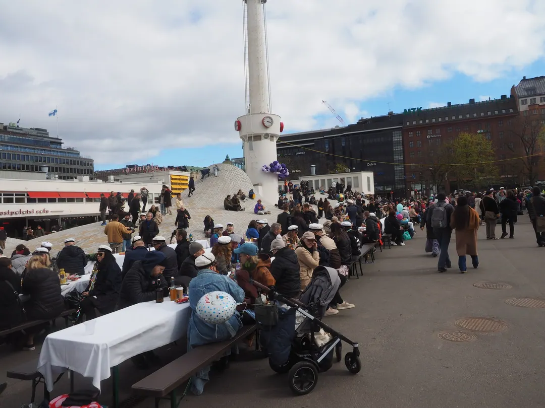 People picnicking on the paving at Lasipalatsinaukio in Helsinki on 1 May