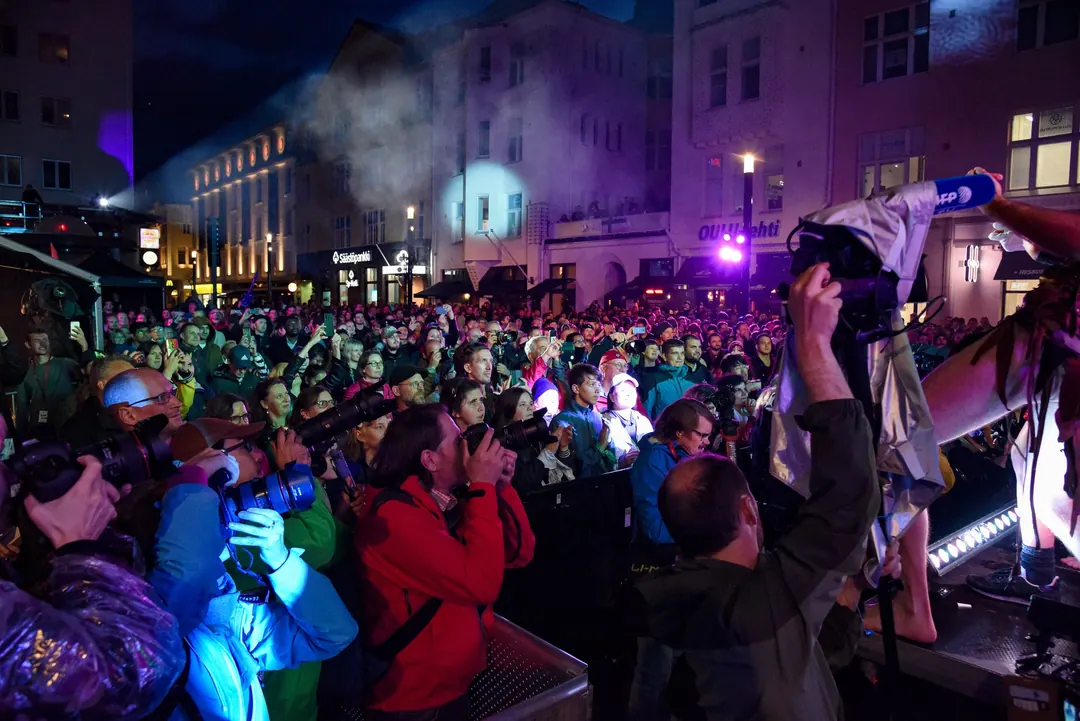 A night crowd at the air guitar championships in Oulu with phones and cameras raised towards the stage