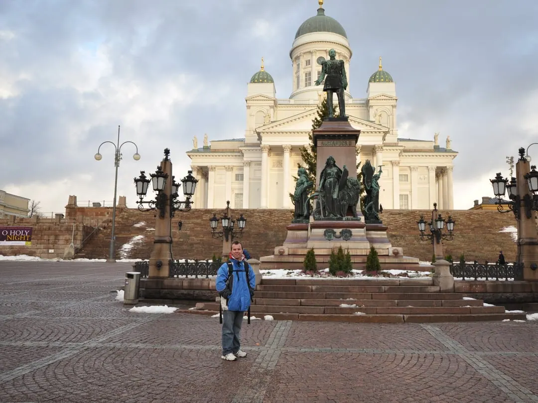 A white neoclassical cathedral with a tall green central dome and four smaller domes, standing above a wide flight of steps