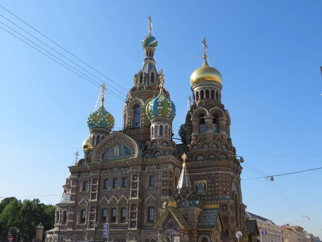 An ornate cathedral with brightly patterned onion domes in green, blue and gold