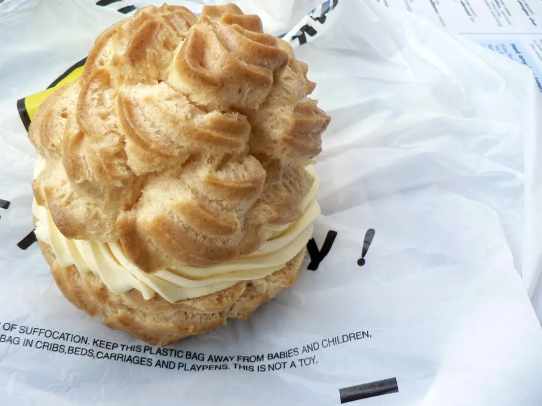 A craggy choux pastry bun filled with pale yellow cream