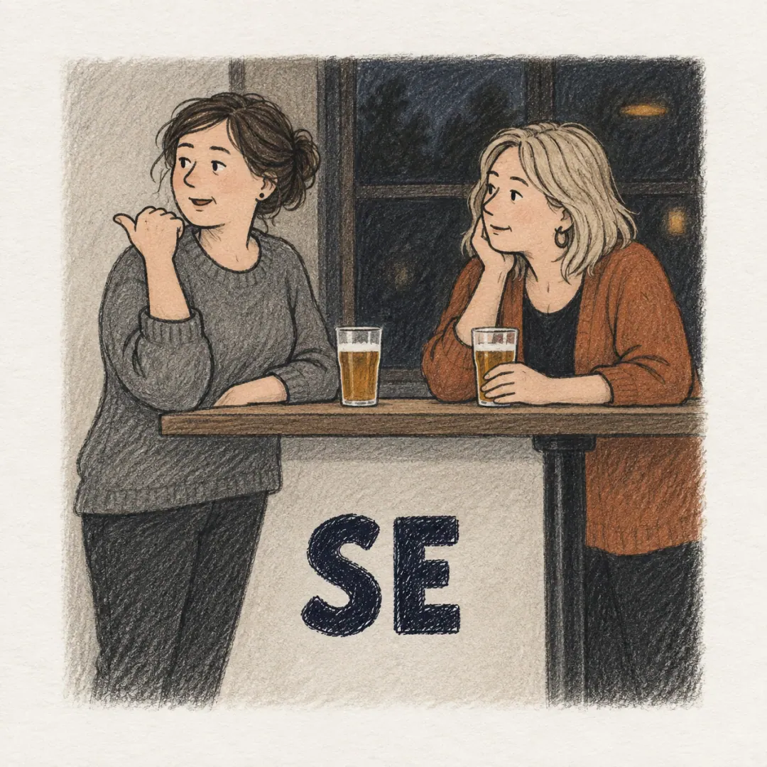 se - two women talking by a bar table, one tipping her chin towards someone off to the side while she talks about them